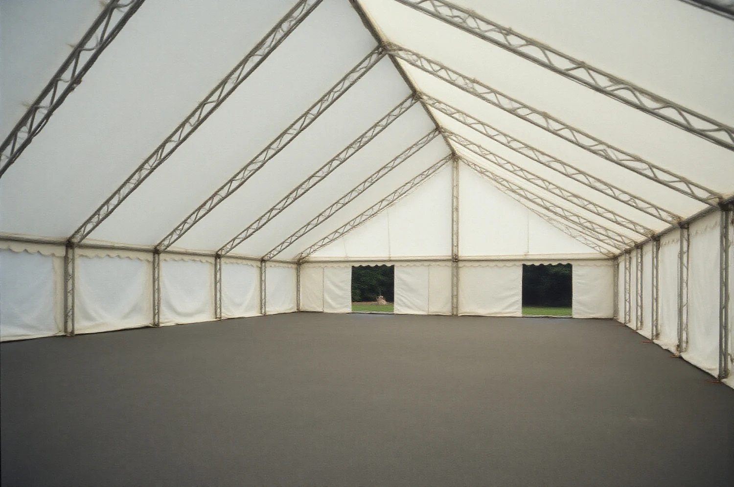 Interior de una carpa de exposición vacía, con la estructura y el piso
